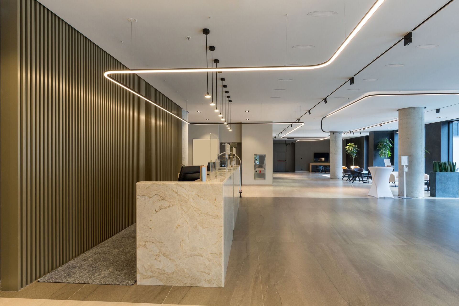 Lobby moderne avec comptoir d'accueil et éclairage linéaire
